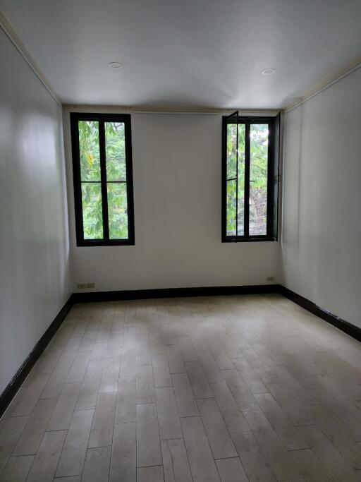 Empty bedroom with two large windows