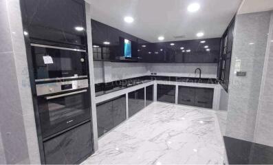 Modern kitchen with marble floor and built-in appliances