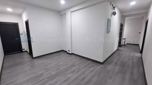 Entrance hallway with grey wooden flooring and multiple doors