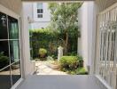 Covered patio with fan and adjacent garden view