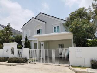 Front view of a modern two-story house with a gated driveway