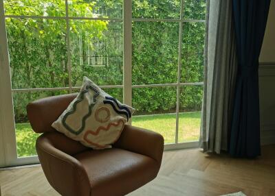 Comfortable chair in front of large window with view of garden