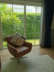 Comfortable chair in front of large window with view of garden