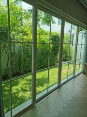 Bright living room with large glass windows overlooking a lush garden