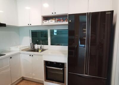 Modern kitchen with white cabinets and stainless steel appliances