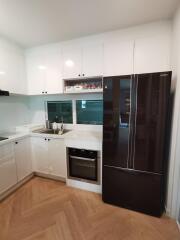 Modern kitchen with white cabinets and stainless steel appliances