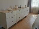 Modern bedroom with large dresser and natural light.