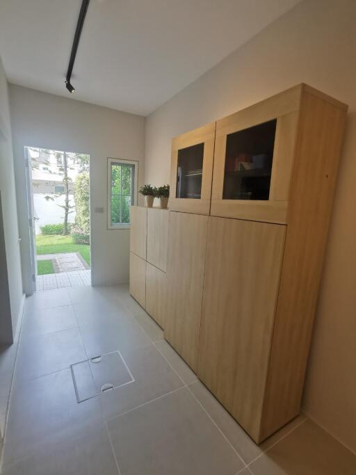 Hallway with wooden cabinets and outdoor view