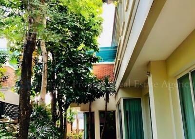 Exterior view of a modern residential building with lush greenery