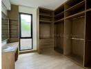 Spacious bedroom with built-in wooden shelving and large window