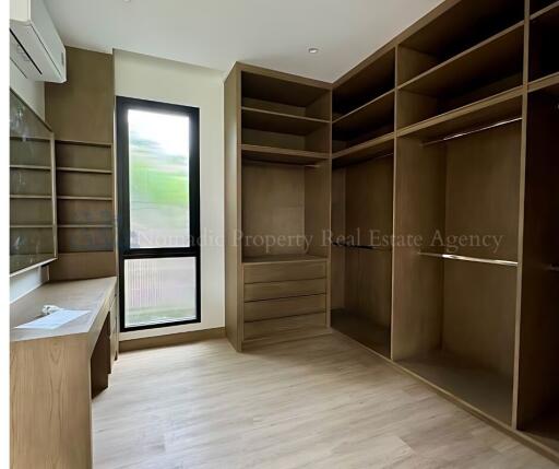 Spacious bedroom with built-in wooden shelving and large window