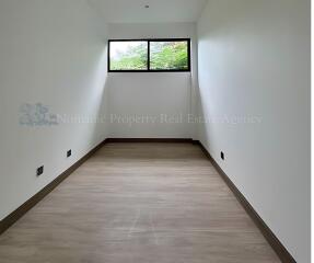 Minimalist bedroom with large window and laminate flooring