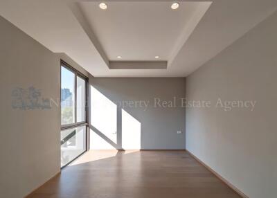 Modern empty living room with large windows and recessed ceiling lights.