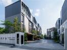 Exterior view of modern multi-story buildings with driveway and greenery