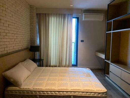 Modern bedroom with brick wall and large window