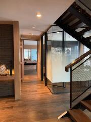 Modern hallway with wooden flooring and a staircase