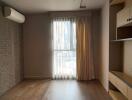 Bedroom with air conditioning, large window, wooden flooring, brick accent wall, and built-in shelves