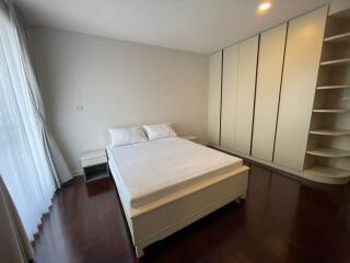 Spacious bedroom with bed, side tables, and ample closet space