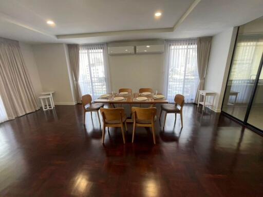 Cozy dining room with a table set for six, hardwood floors, and plenty of natural light.