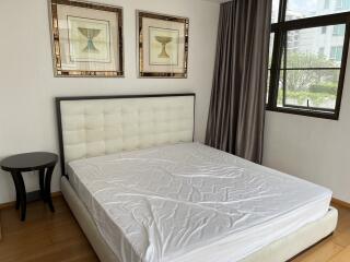 Modern bedroom with large window and framed artwork