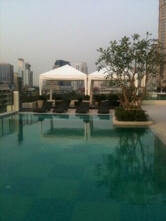 Rooftop swimming pool with lounge area and city view