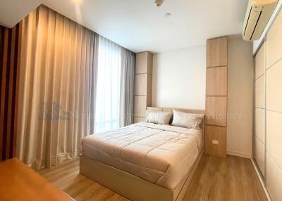 A cozy bedroom with wooden flooring and ambient lighting.