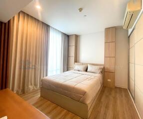 A cozy bedroom with wooden flooring and ambient lighting.