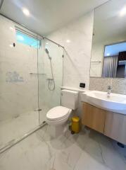 Modern bathroom with glass shower, toilet, and sink