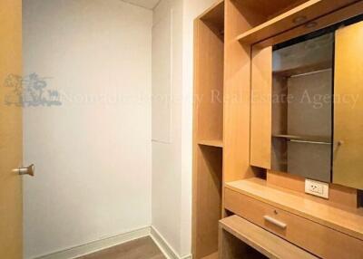 Walk-in closet area with wooden shelves and drawers