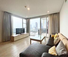 Bright living room with city view, modern furniture, and large windows