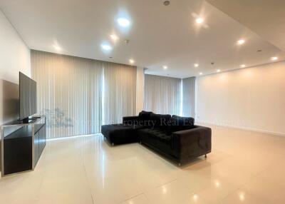 Spacious modern living room with ample lighting and a large sectional sofa