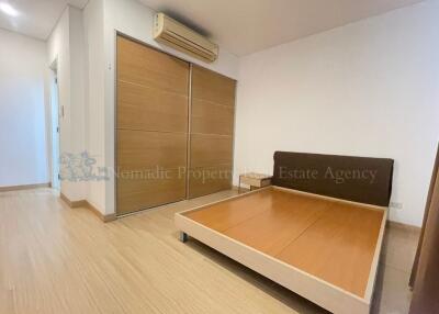 Spacious bedroom with wooden flooring and air conditioning