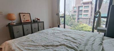 Bedroom with large window and city view