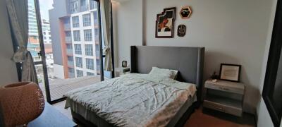 A modern bedroom with a large window and fashionable decor.