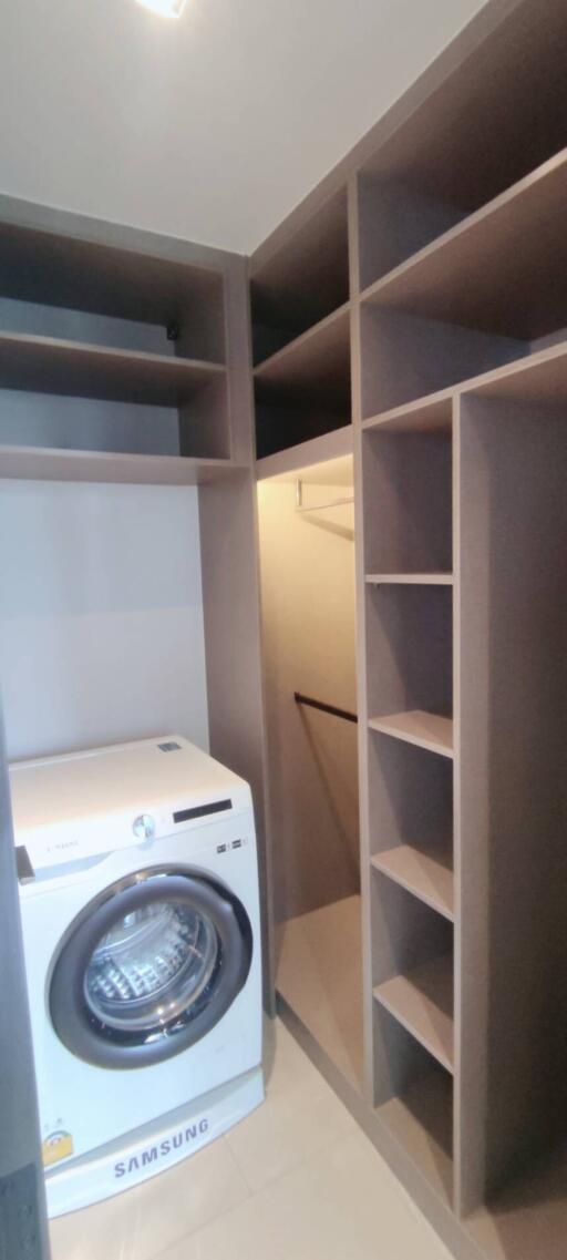 Laundry room with washing machine and built-in shelving