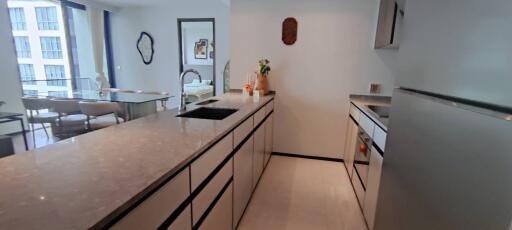 Modern kitchen with island and view into dining and sleeping areas