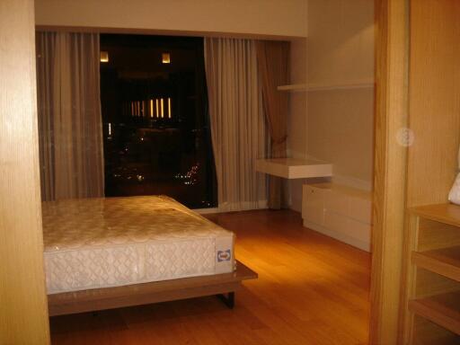 Modern bedroom with a large bed and wooden flooring