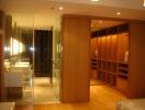 Spacious dressing room with built-in wooden closets and adjoining bathroom.
