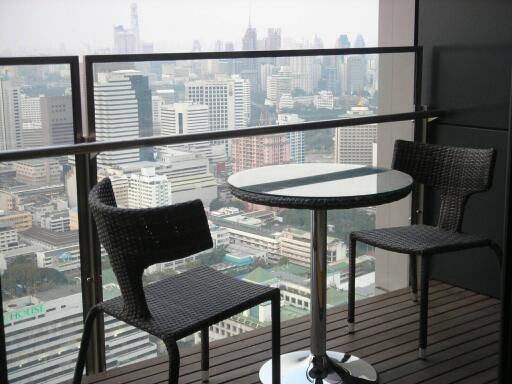 Balcony with a view of city skyline, furnished with a small round table and two chairs