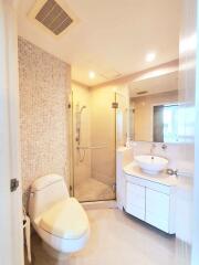 Modern bathroom with glass shower, vanity, and toilet