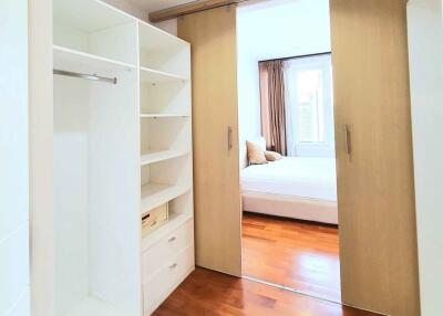 Spacious bedroom with walk-in closet and wooden flooring