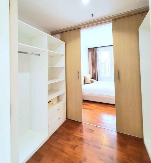 Spacious bedroom with walk-in closet and wooden flooring