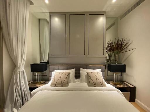 Elegant modern bedroom with double bed, bedside tables, and decorative mirrors