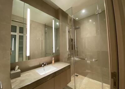 Modern bathroom with glass-enclosed shower and large mirror