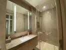 Modern bathroom with glass-enclosed shower and large mirror