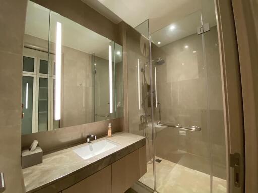 Modern bathroom with glass-enclosed shower and large mirror