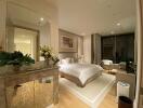 Modern bedroom with a large bed, nightstands, plants, and a seating area