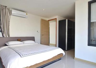 Modern bedroom with a bed, bedside table, air conditioning, and wardrobe