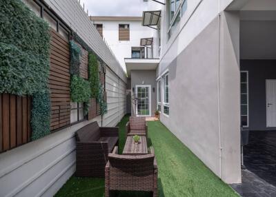 Outdoor seating area with artificial grass and wall plants