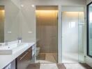 Modern bathroom with double sink vanity, glass-enclosed shower, and large window